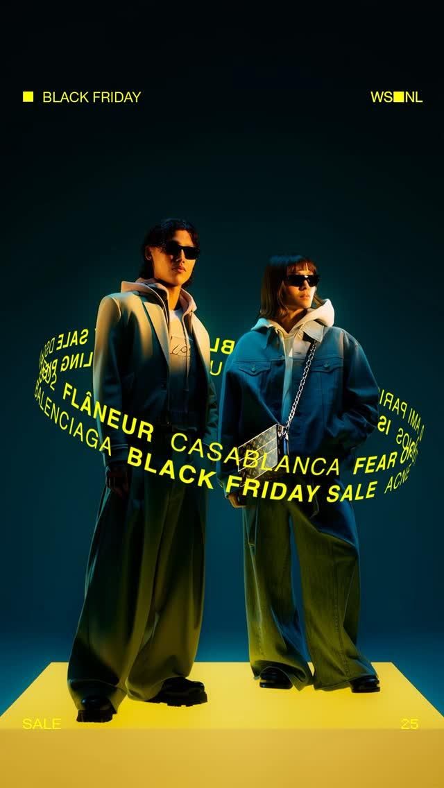 Two models in oversized streetwear on a yellow plinth, circled by a ring of text