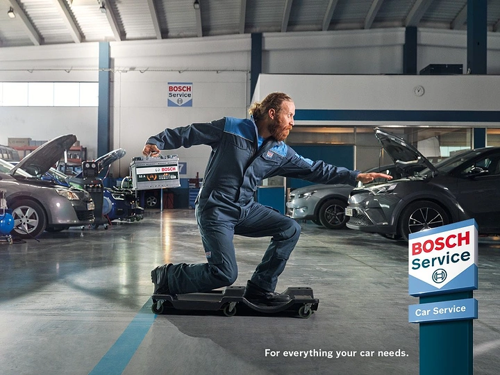 Auto Repair & Garages creative ad: Mechanic gliding on creeper, Bosch humour