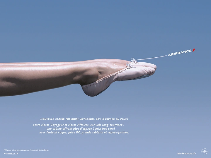 Creative ad: Dancer's extended leg in pointe shoe against sky, mimicking aircraft fuselage