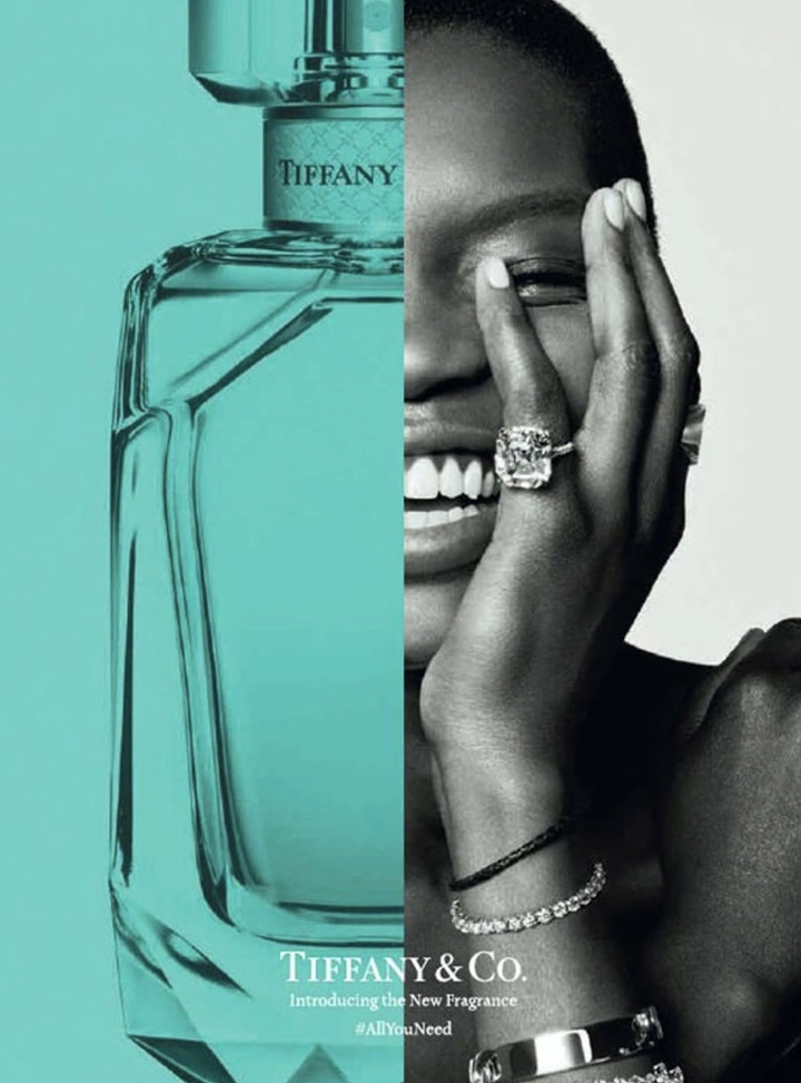 Perfume & Fragrance creative ad: Split image of a turquoise-tinted perfume bottle and a smiling model wearing diamonds