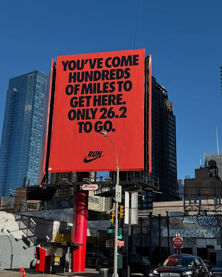 Activewear & Gym Wear creative ad: Red-orange typographic billboard over a city street