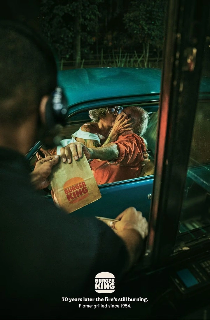 Valentine's Day creative ad: Elderly couple kissing in a vintage car at a night drive-thru
