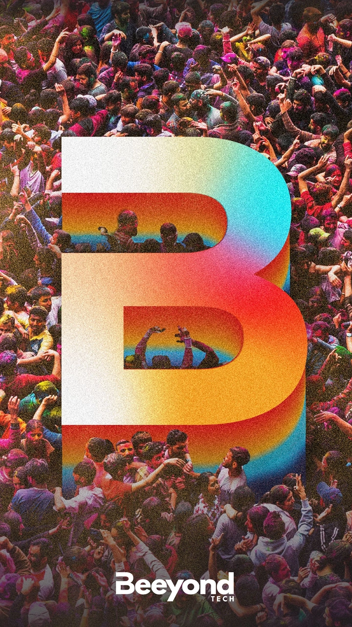 Holi creative ad: Giant rainbow-gradient 3D letter B over an aerial Holi crowd