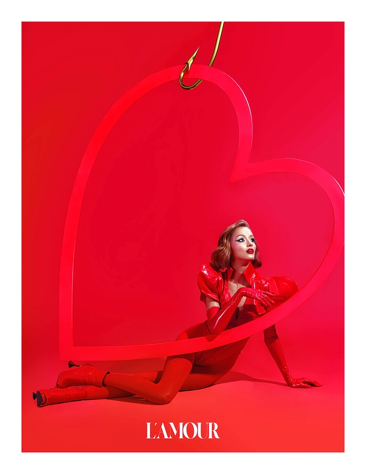 Valentine's Day creative ad: Retro-styled model in red patent leather posing inside a giant heart hung on a fishhook