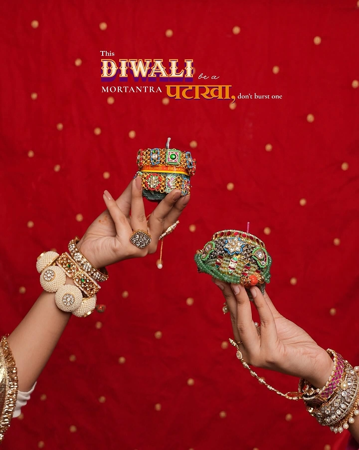 Diwali creative ad: Hands holding jewelled cracker-shaped candles