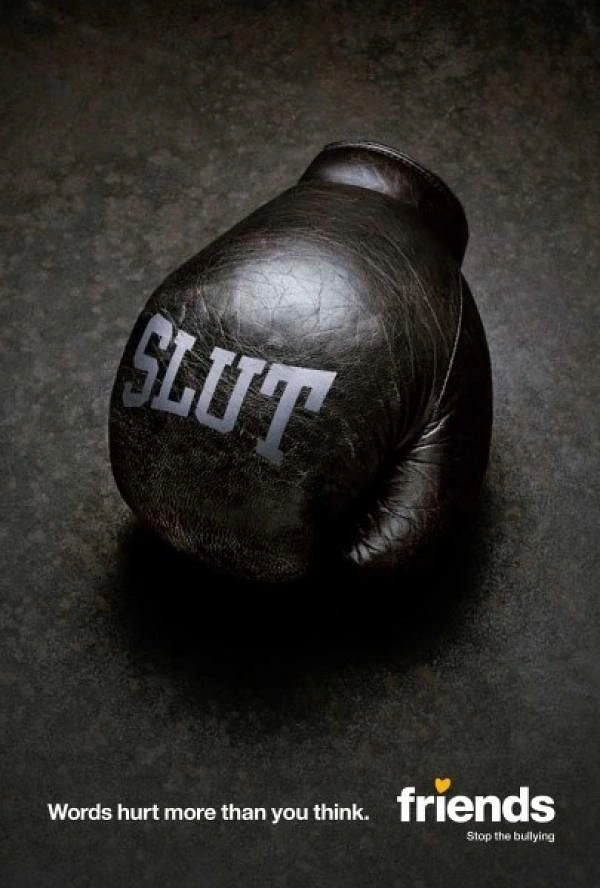 Education creative ad: Worn black leather boxing glove with an insult printed on it