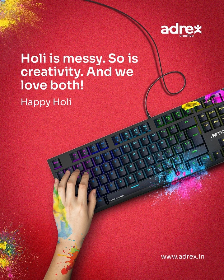 Holi creative ad: Hand with Holi colour typing on an RGB keyboard