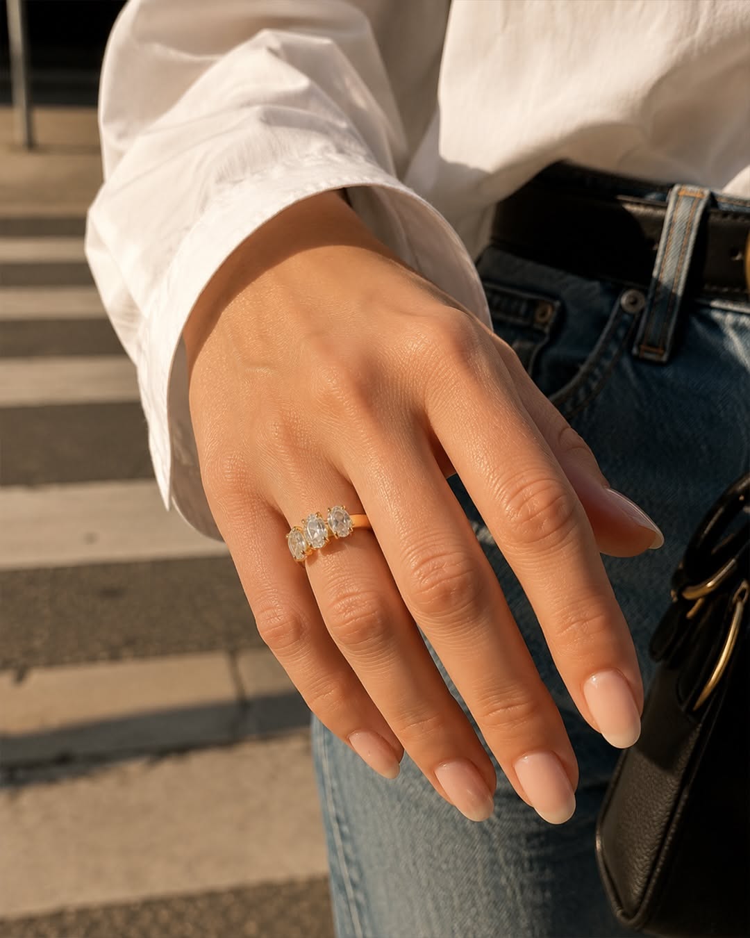 Carousel: Woman in white shirt and jeans crossing a street, with jewelry close-up callouts, slide 4