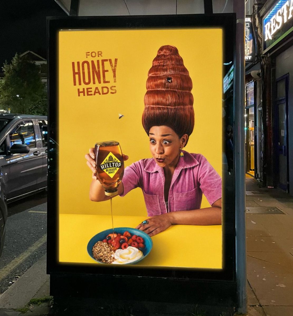 Poster: Woman with a beehive hairdo drizzling honey on a bowl
