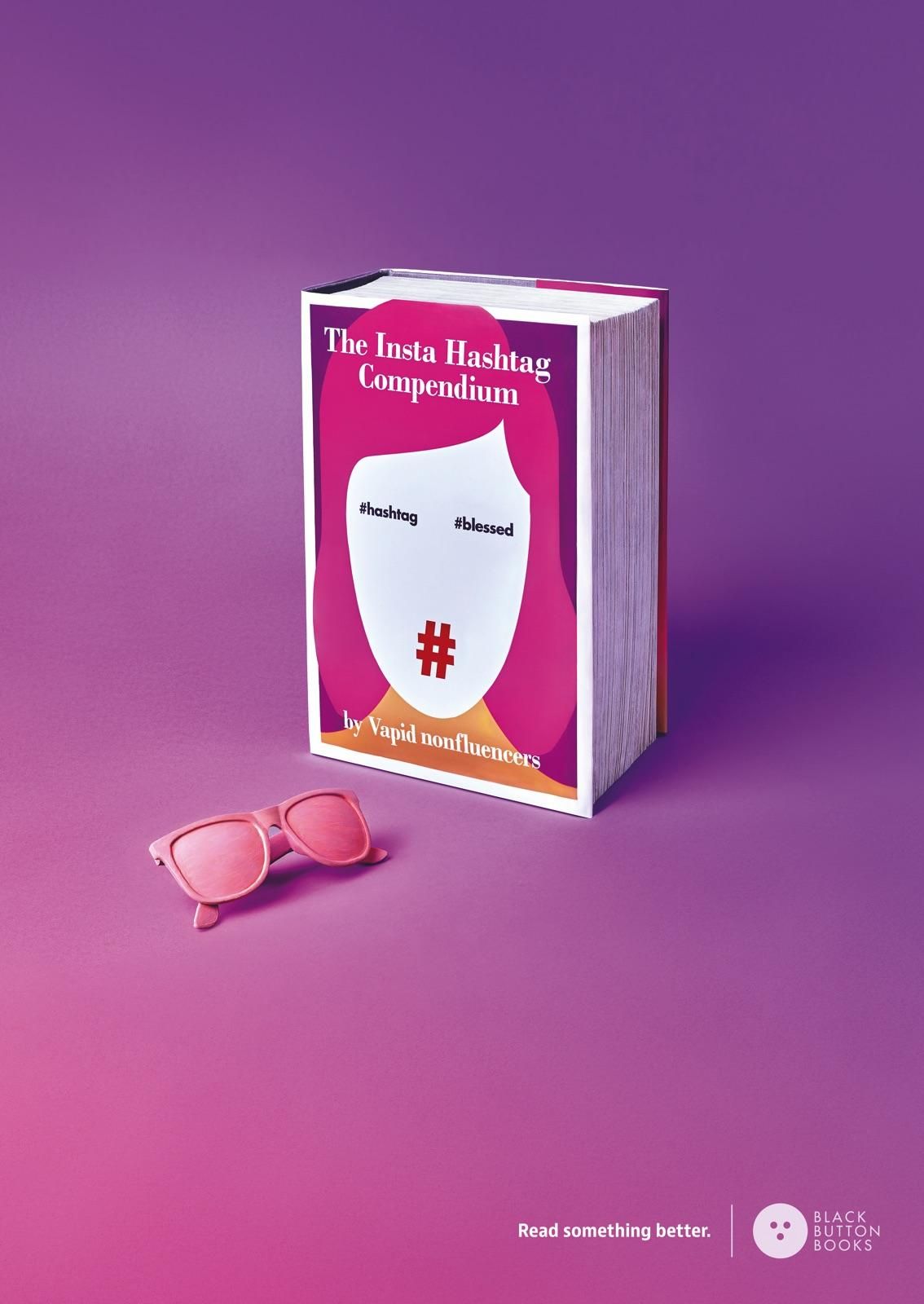 Oversized book with satirical influencer cover beside pink sunglasses