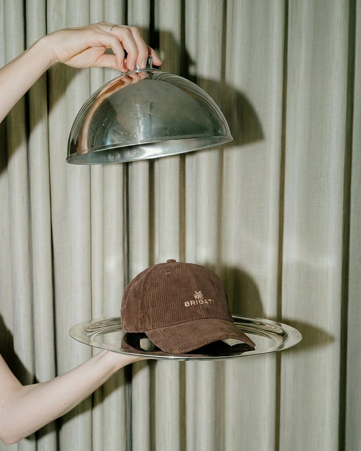 Hats & Caps creative ad: Caps presented as covered-dish treasures