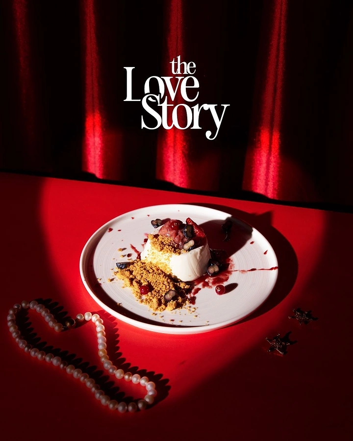 Valentine's Day creative ad: Plated panna cotta dessert with berries and crumble under a spotlight