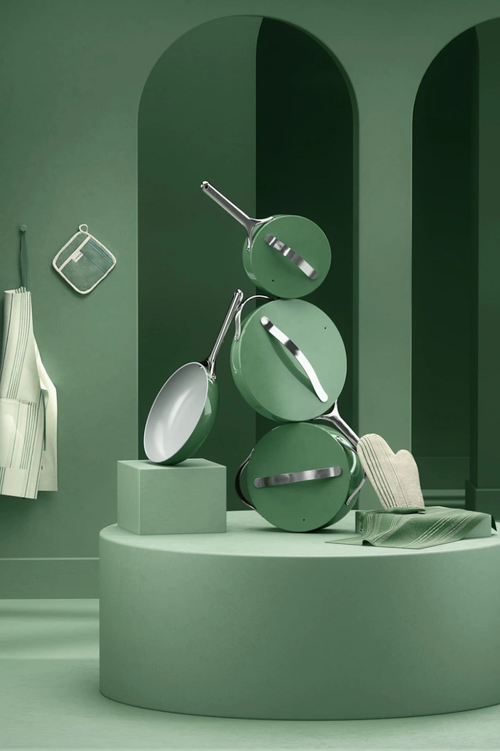 Home Decor creative ad: Sage-green cookware set balanced in a sculptural stack on a plinth