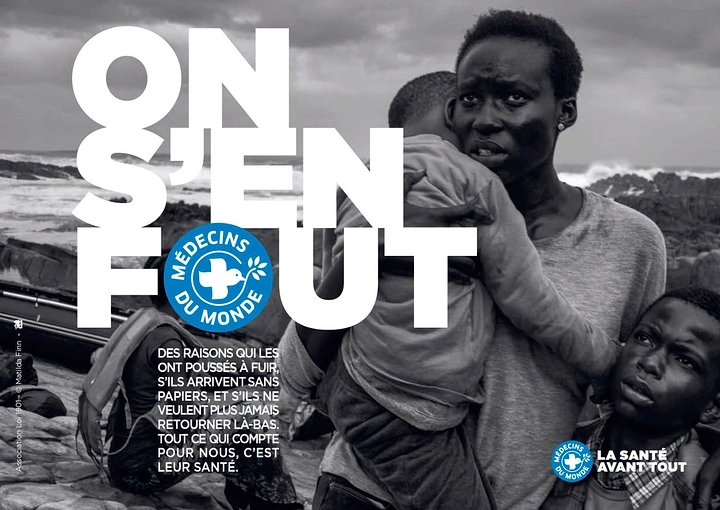 Creative ad: Migrant mother carrying child on rocky shore