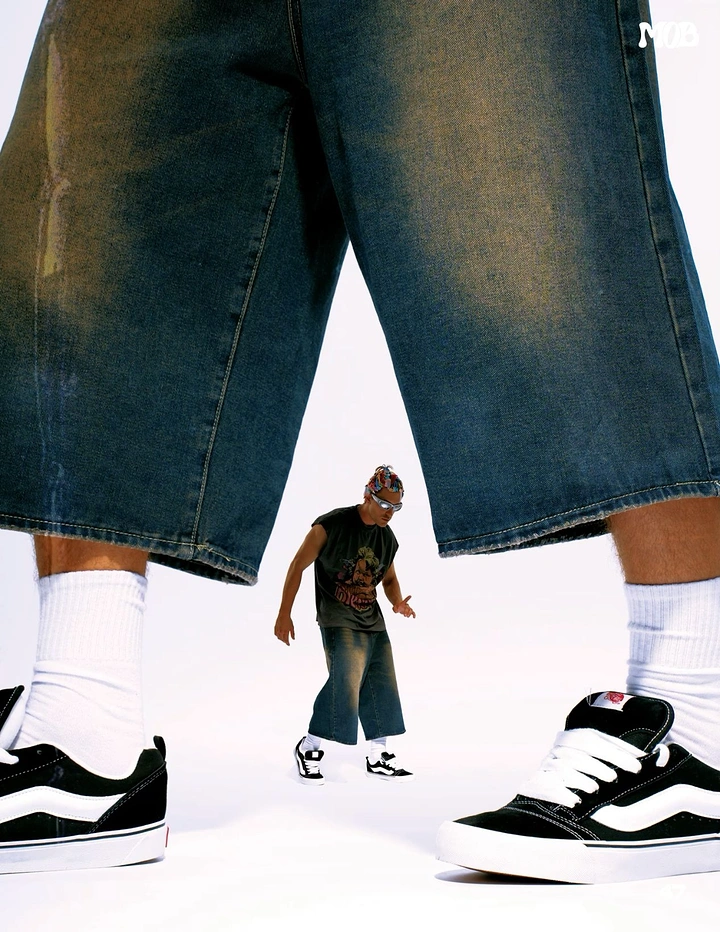 Streetwear creative ad: Giant legs in baggy jorts framing a tiny model