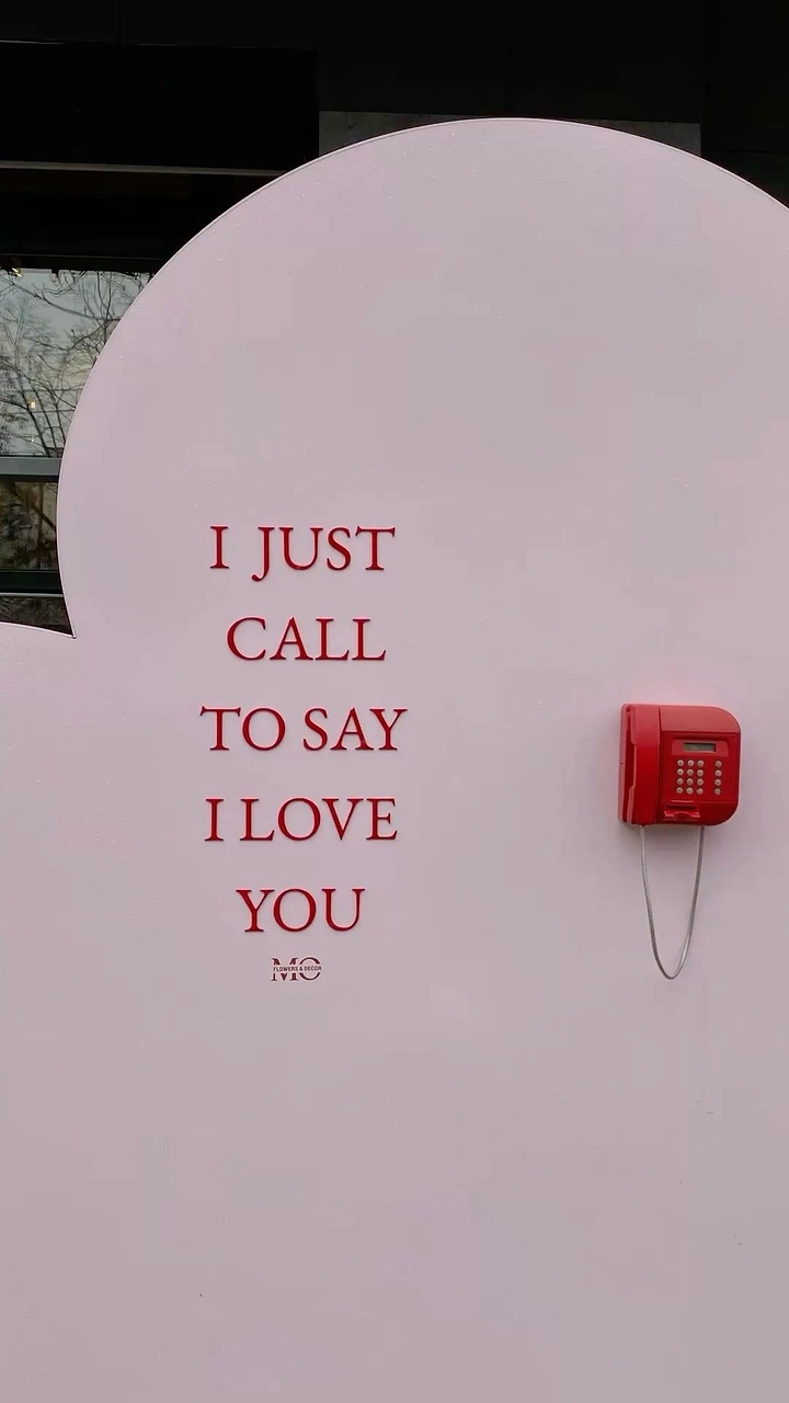 Valentine's Day creative ad: Red wall-mounted telephone on a pale pink cloud-shaped installation