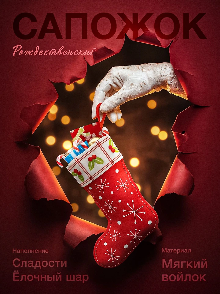 Christmas creative ad: Gloved hand holding a red felt Christmas stocking through torn paper