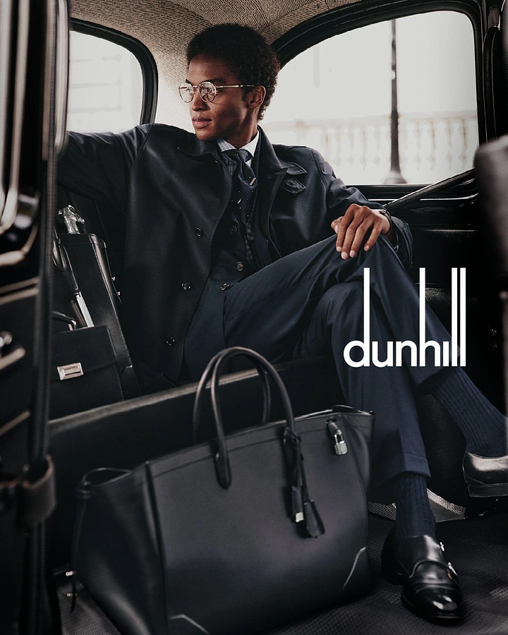 Fashion creative ad: Well-dressed man seated in a vintage automobile
