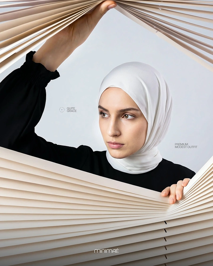 Modest Fashion, Hijabs & Abayas creative ad: Model in a white hijab and black dress peering through parted cream blinds