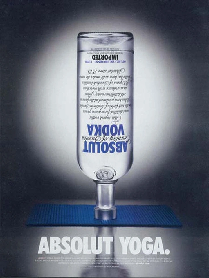 Creative ad: Vodka bottle balancing upside down on its neck on a blue yoga mat
