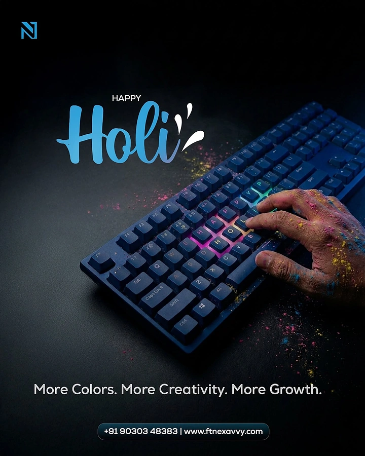 Holi creative ad: Colour-powdered hand typing on a dark keyboard with keys lit in rainbow