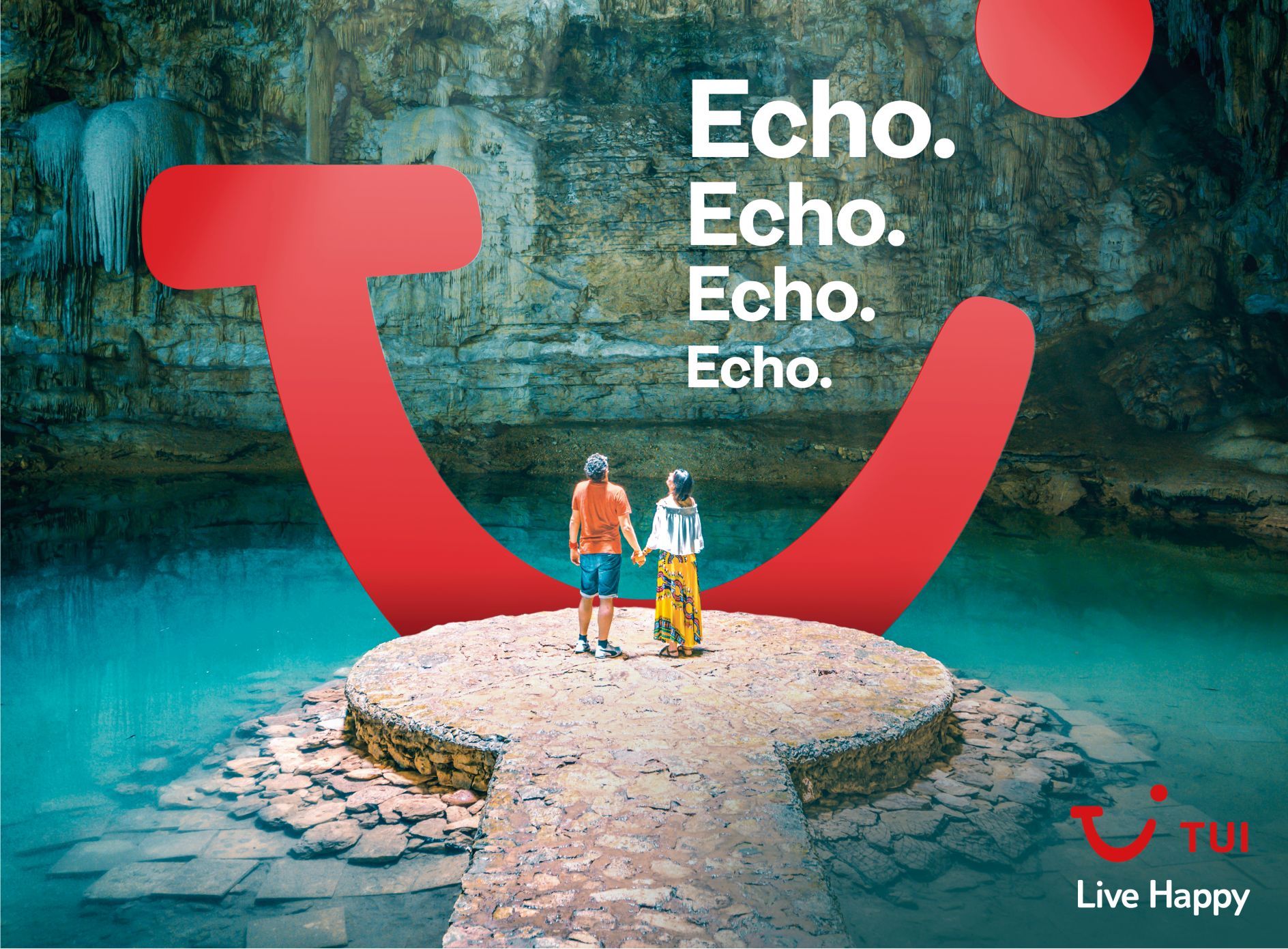 Couple on a stone platform in a cenote, framed by a giant red smile brand mark