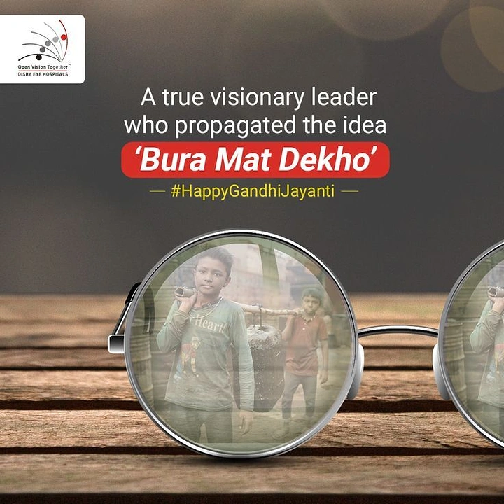 Gandhi Jayanti creative ad: Round spectacles on a wooden table with child labourers reflected in the lens