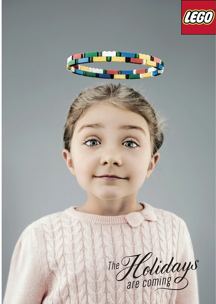 Christmas creative ad: Wide-eyed girl with a halo made of colourful bricks
