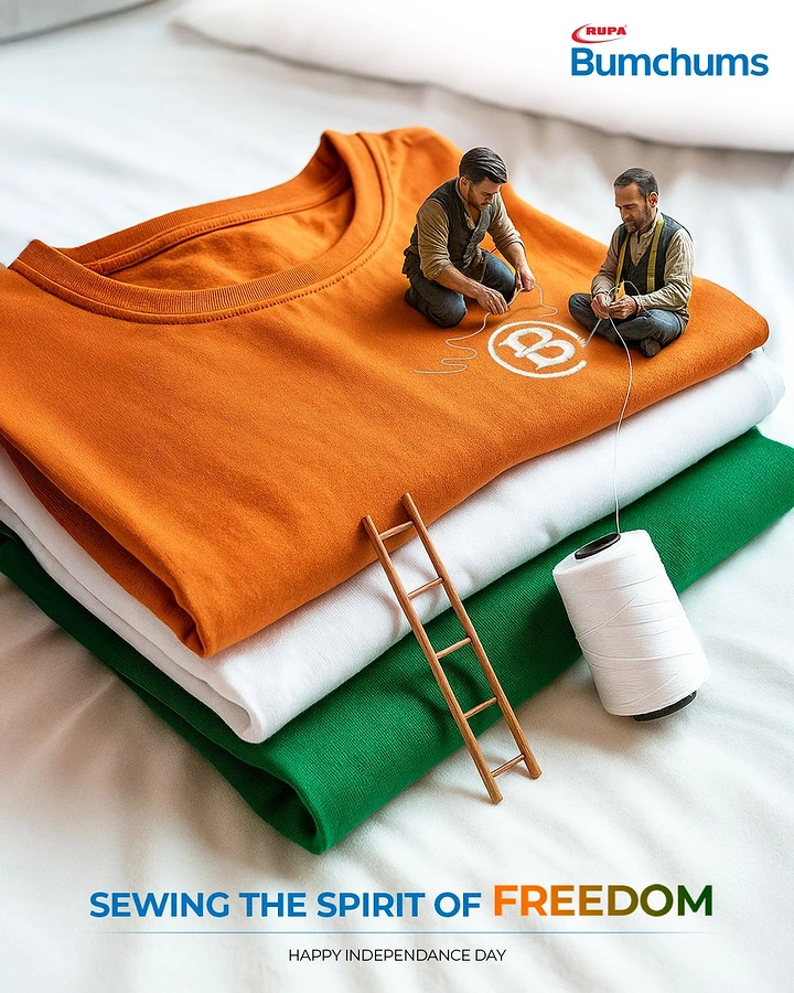 Independence Day creative ad: Miniature tailors stitching a logo on stacked saffron, white and green t-shirts