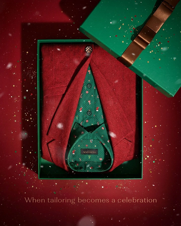 Christmas creative ad: Folded red jacket and festive shirt in open gift box