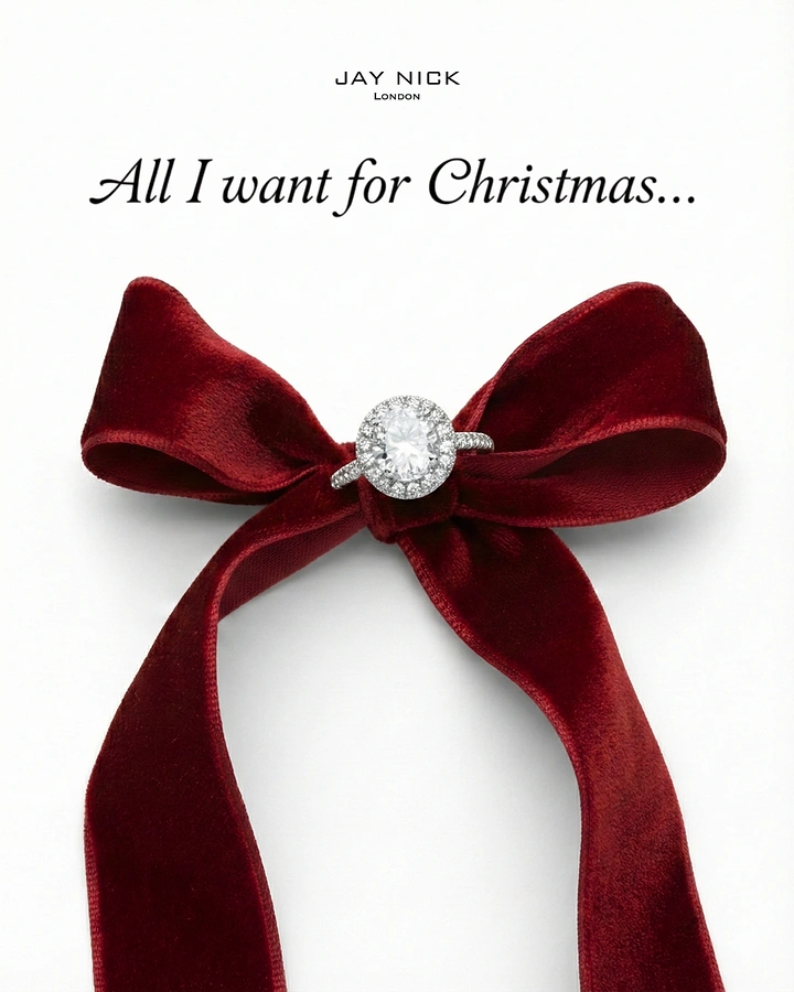 Christmas creative ad: Diamond halo engagement ring tied at the centre of a red velvet bow