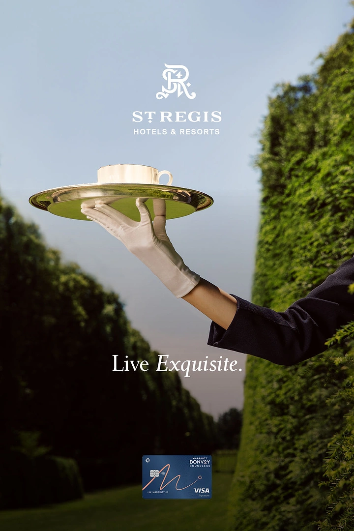 Creative ad: Gloved butler's arm holding a tray with a teacup between tall hedges