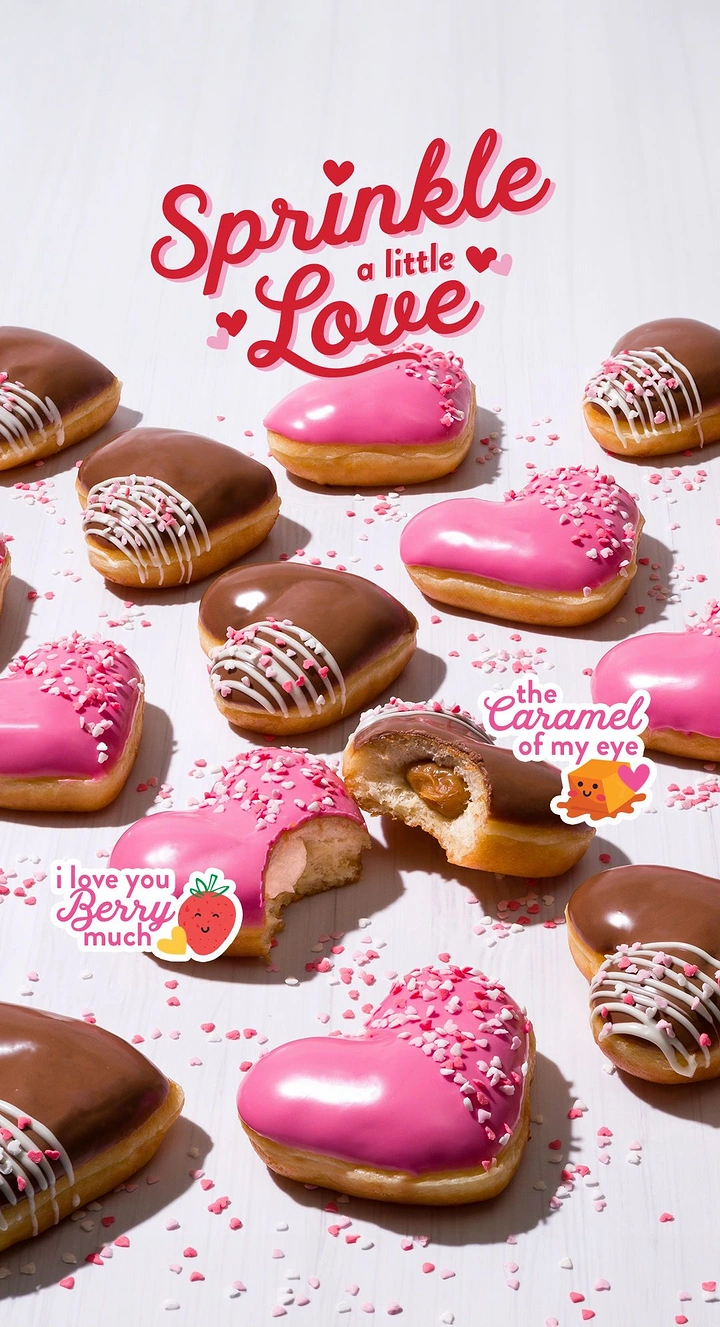 Valentine's Day creative ad: Scattered heart-shaped glazed doughnuts with pink sprinkles
