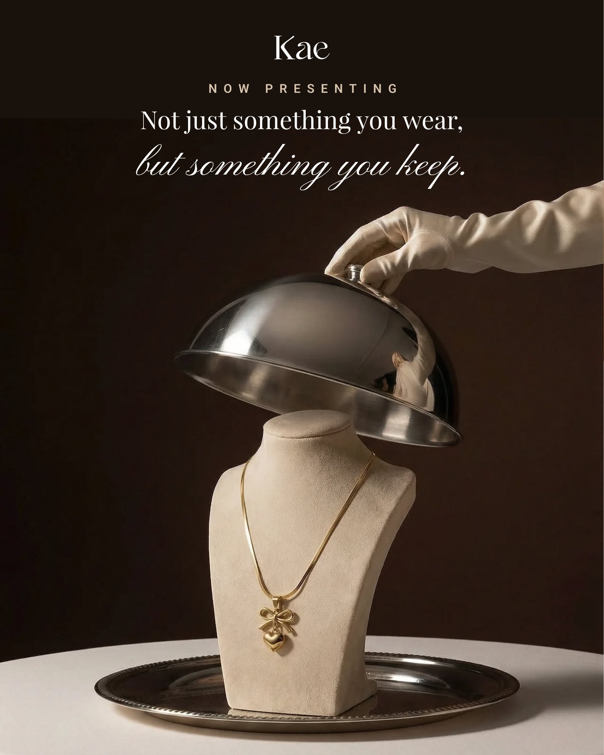 Instagram post: Gloved hand lifting a silver cloche to reveal a gold pendant on a bust