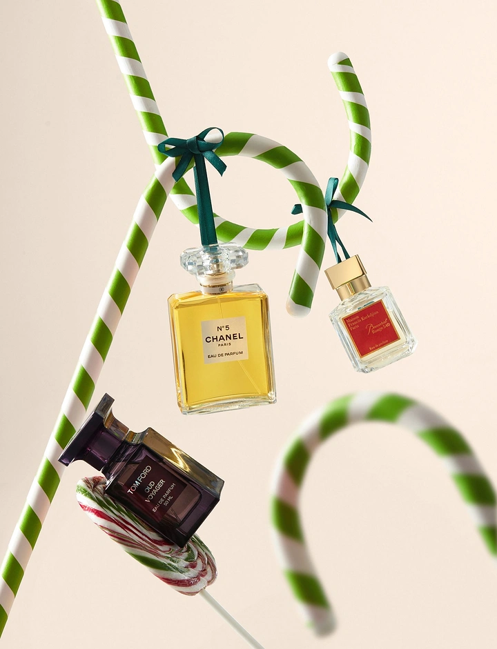 Christmas creative ad: Perfume bottles hanging from green-and-white candy canes