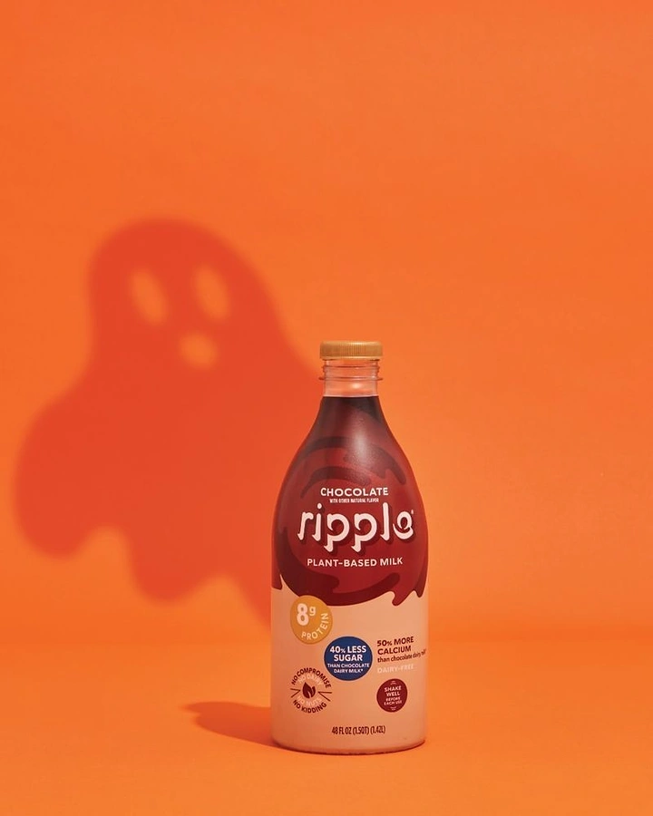 Halloween creative ad: Plant-based milk bottle casting a ghost-shaped shadow