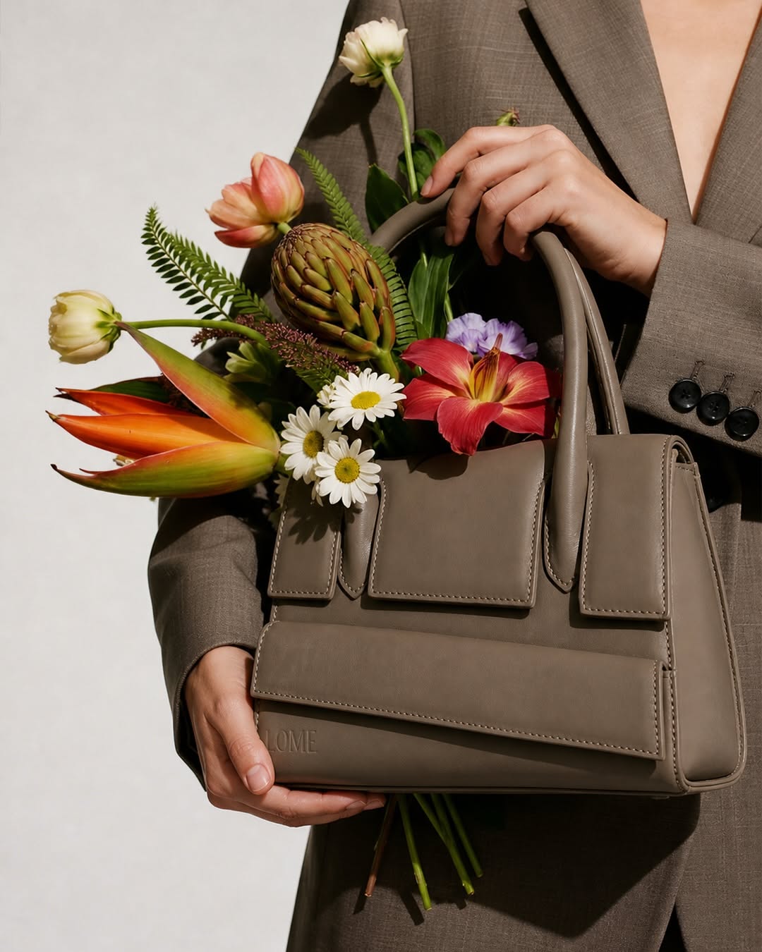 Mother's Day Carousel: Suited figure holding a branded shopping bag and a loose bouquet, slide 2