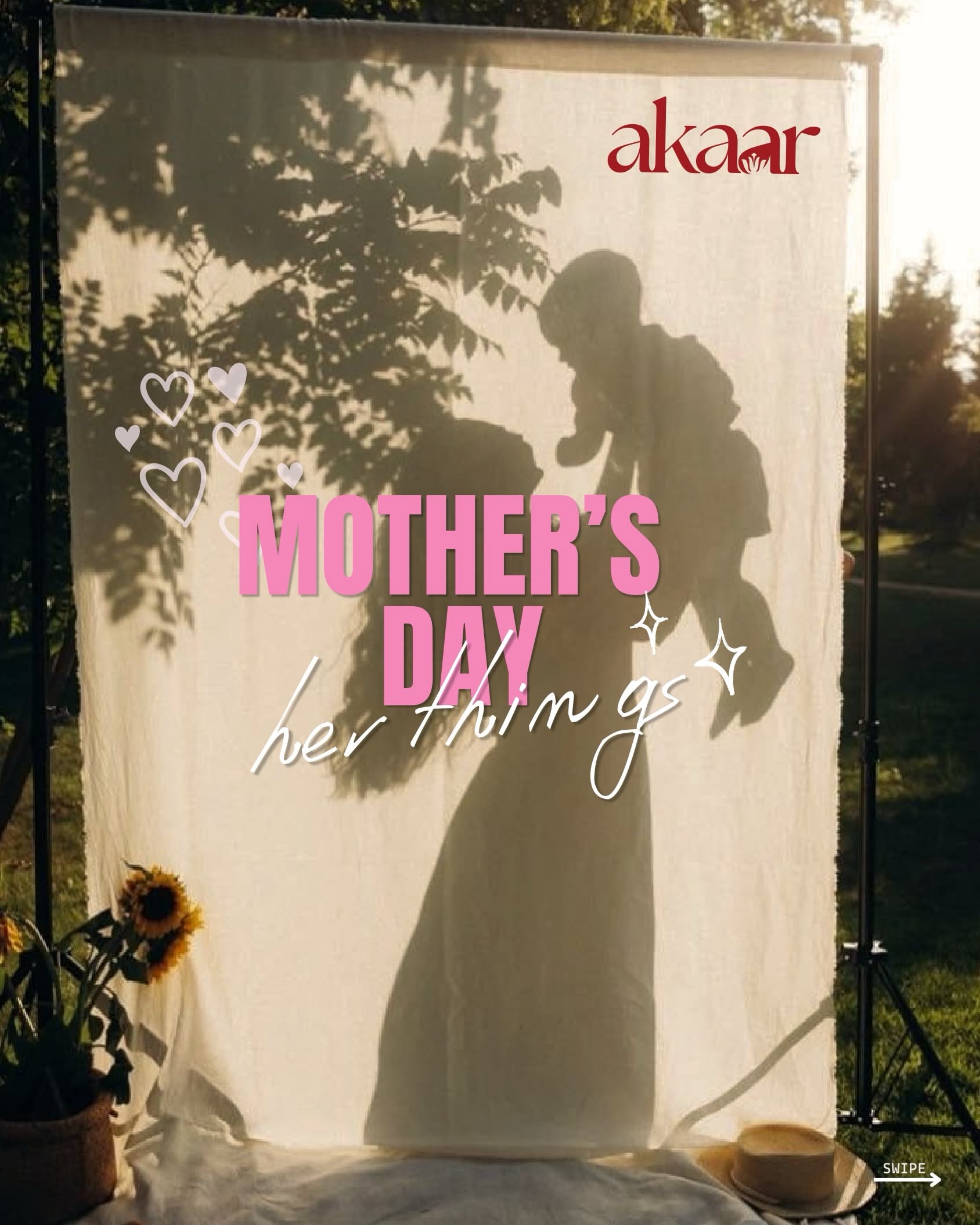 Shadow of a mother lifting her baby on a sunlit cloth backdrop