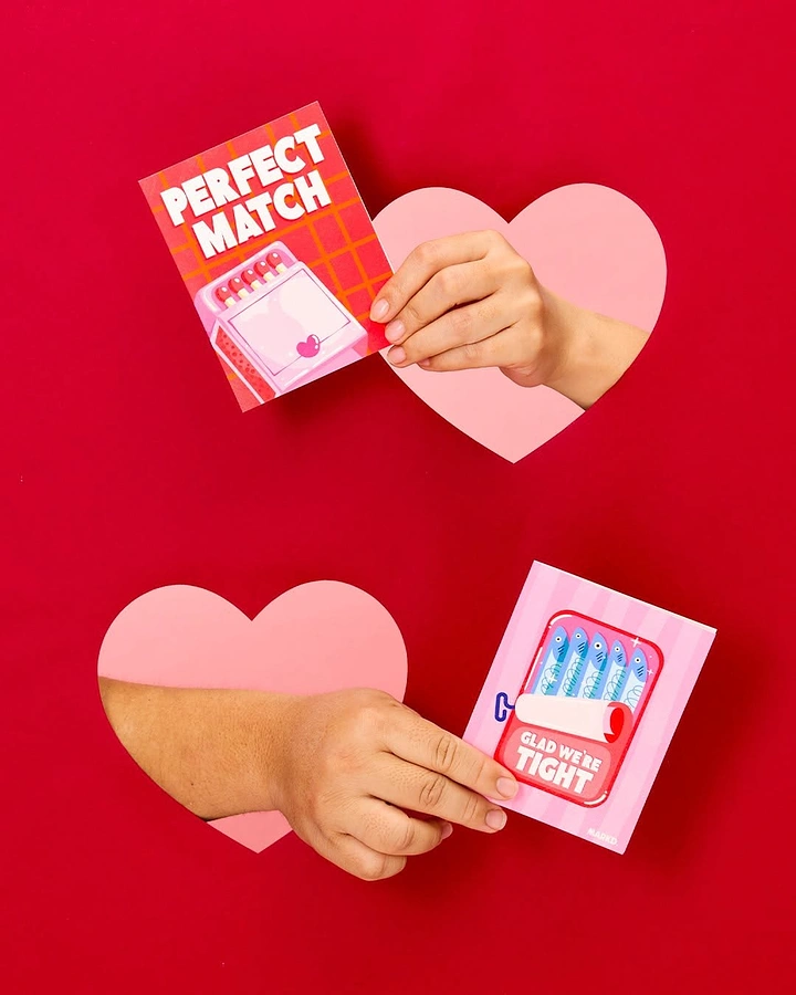 Valentine's Day creative ad: Hands through heart cut-outs holding pun cards