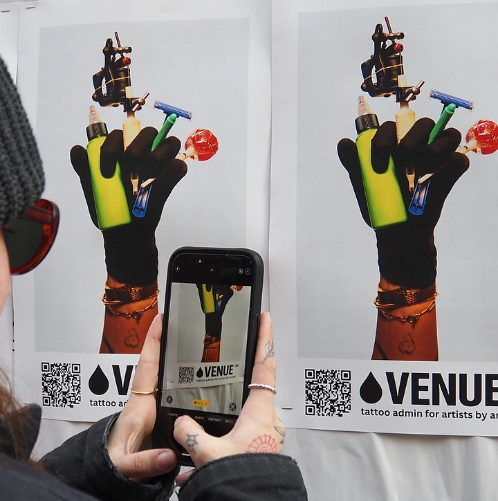 Tattoo Studios creative ad: Gloved hand holding tattoo tools, bold poster