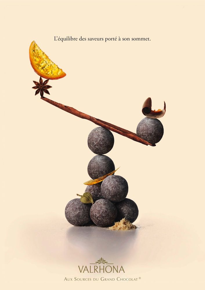 Poster: Stacked cocoa truffles balancing a cinnamon-stick seesaw with spices