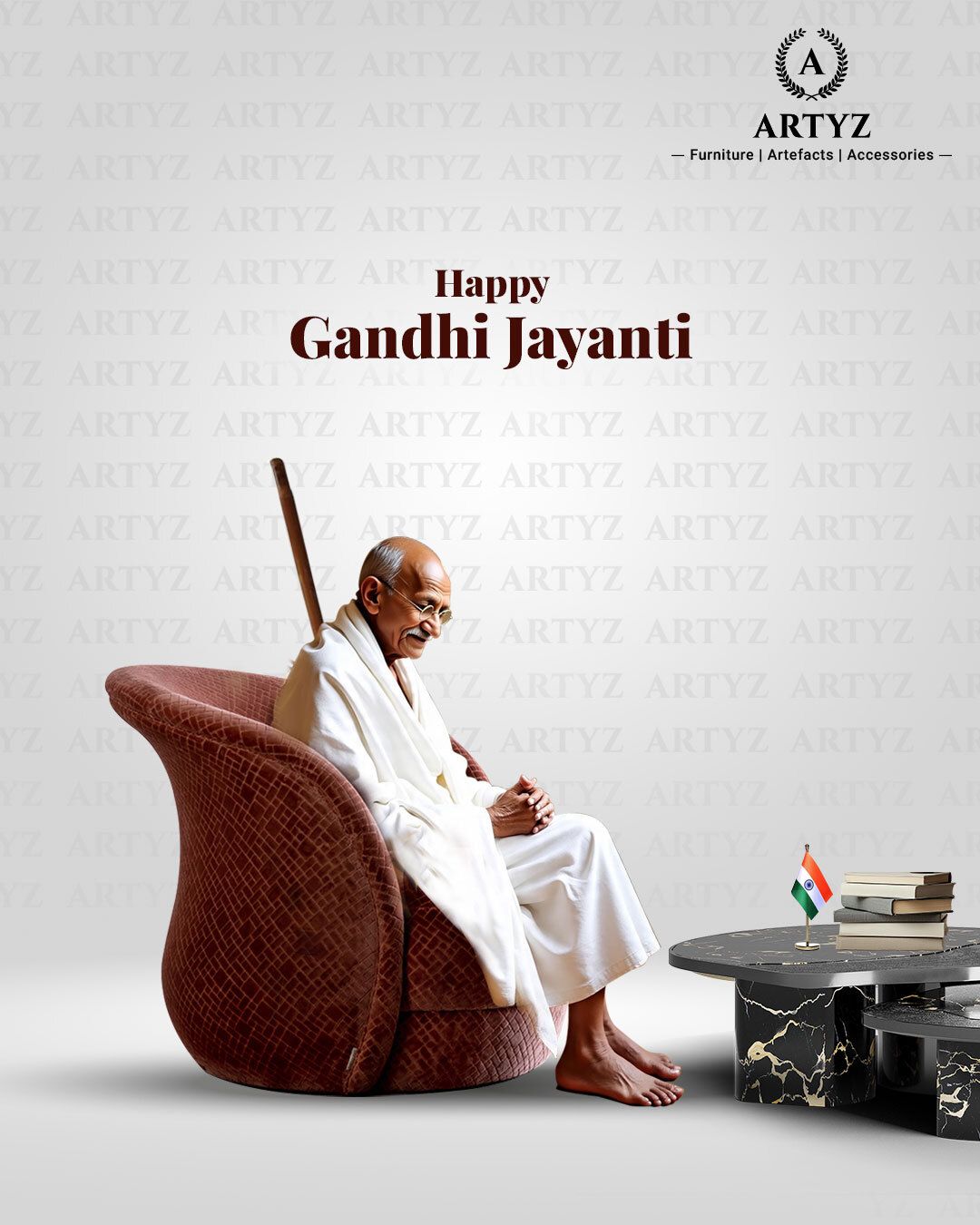 Gandhi seated in a textured maroon armchair beside a marble table