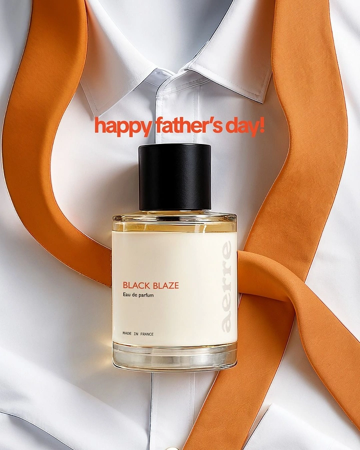 Father's Day creative ad: Perfume bottle laid on a crisp white shirt with a looping orange tie