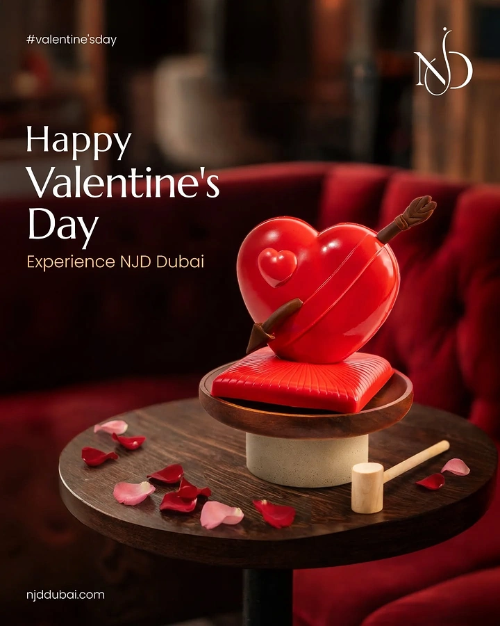 Valentine's Day creative ad: Glossy red breakable chocolate heart with an arrow on a café table