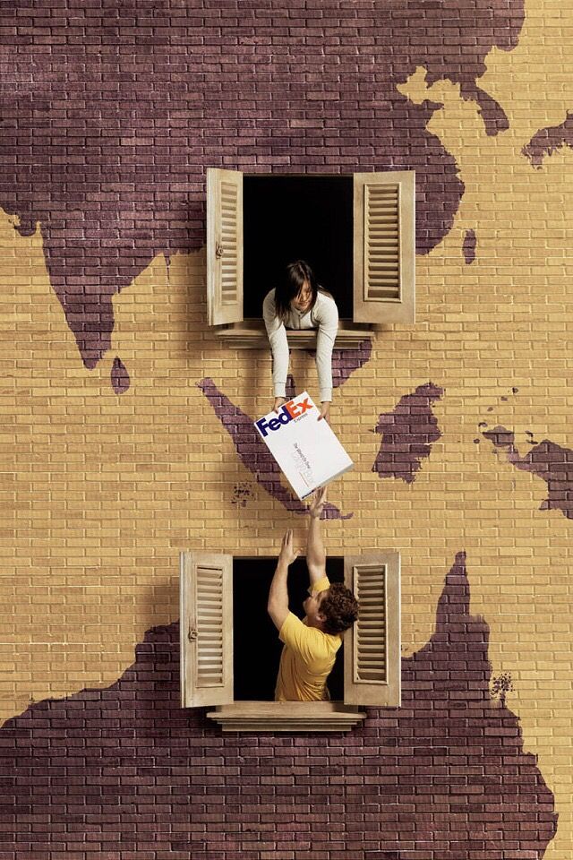 Instagram post: Parcel passed between two windows on a brick wall painted as a world map