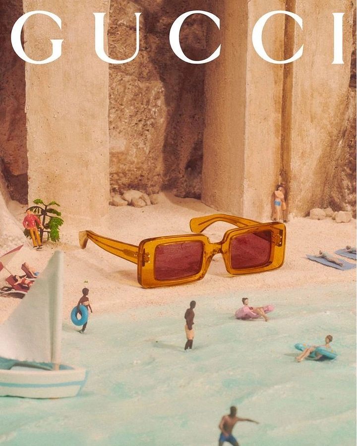 Creative ad: Giant amber sunglasses on a miniature beach diorama