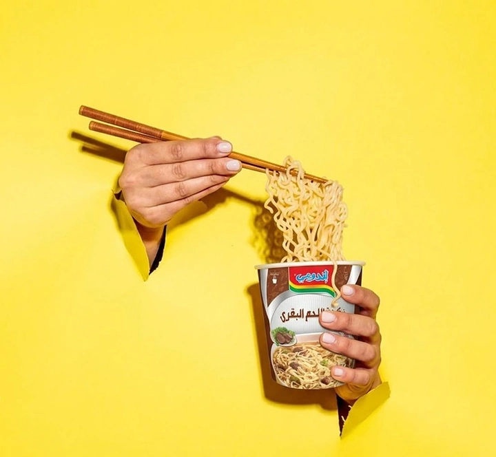 Instant Noodles & Pasta Brands creative ad: Surreal hands-through-yellow noodle presentation
