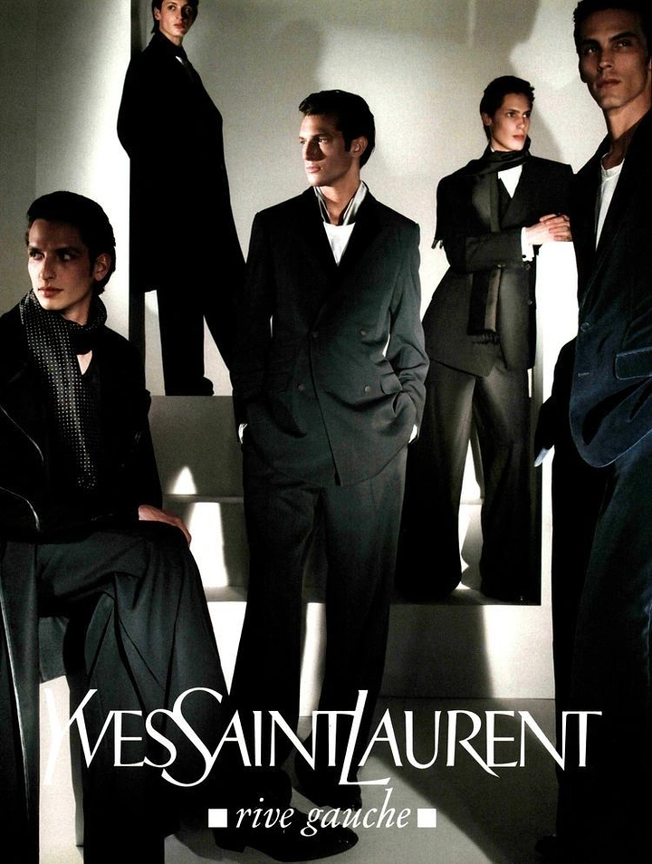 Fashion creative ad: Group of models in black tailoring posed in a stark interior