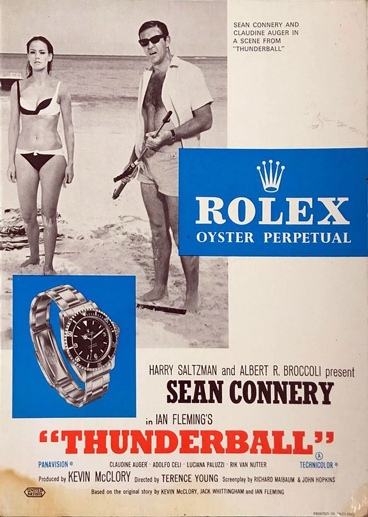 Cinemas & Movie Theatres creative ad: Film still of a spy and a bikini-clad woman on a beach, with a steel dive watch