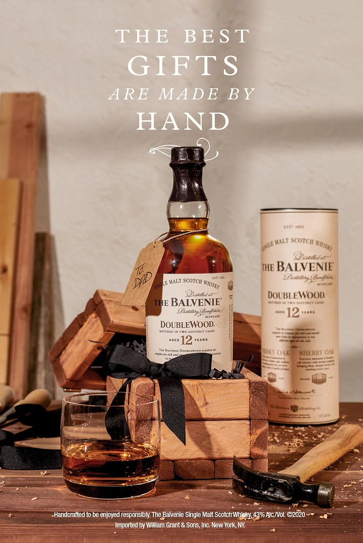 Father's Day creative ad: Whisky bottle with 'To: Dad' tag on handmade wooden gift box